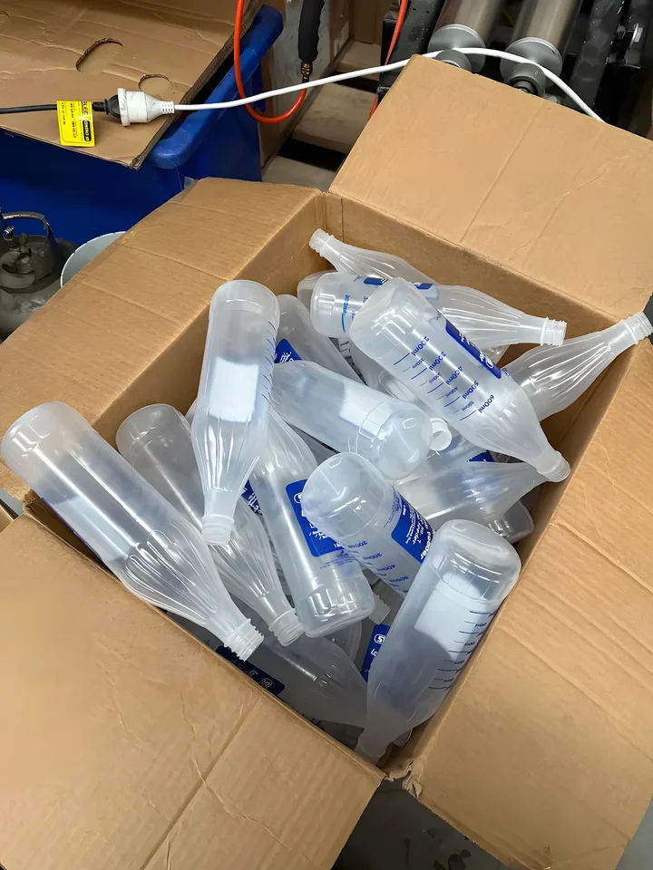 A box of freshly printed measuring bottles ready for pickup
