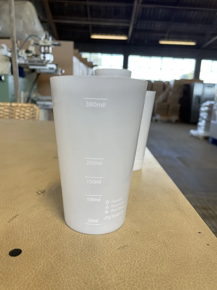 Frosted cup printed with measuring marks, on the workbench